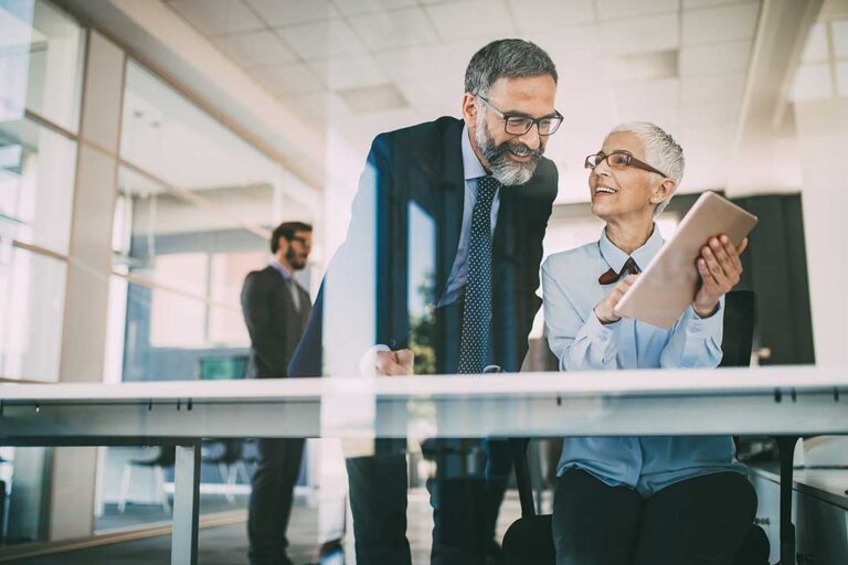Retired couple reviewing monthly income documents beside a calculator and household budget.